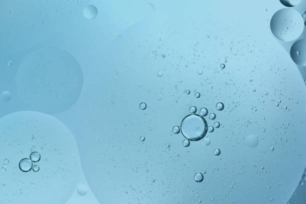 istock oil drop floating or Cosmetic liquid serum on the water blue bubbles 1334126617
