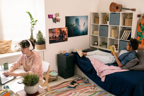 istock Two restful teenagers reading book and networking in bedroom 1334127415