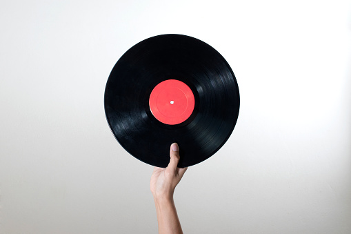 Man hand holding old vinyl retro record music audio isolated on white background