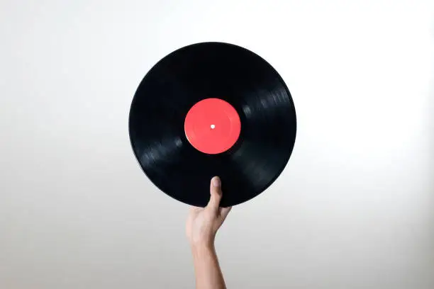 Photo of Man hand holding old vinyl retro record music audio isolated on white background