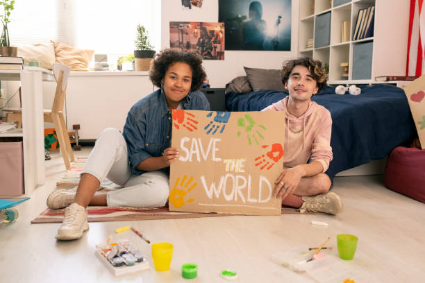 istock Happy teens showing handmade placard about saving planet 1334127603