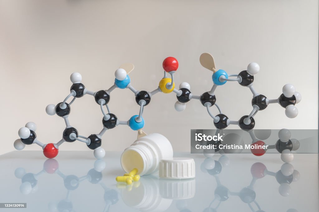 Omeprazole pills and pill bote with omeprazole chemical formula made by molecular model in the background. Picture of omeprazole pills and pill bote with omeprazole chemical formula made by molecular model in the background. Helicobacter Stock Photo