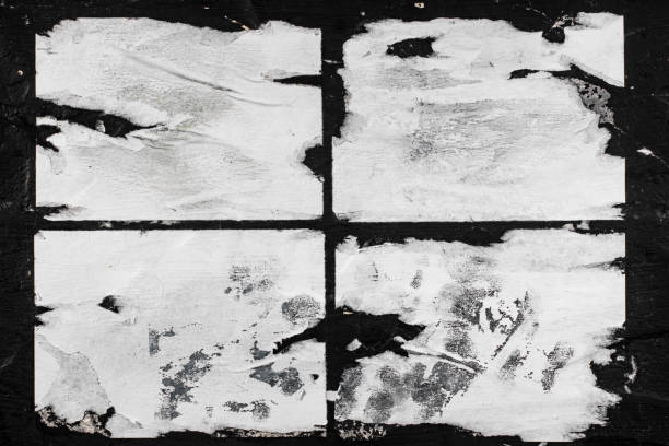 istock Torn sheets of white paper glued to the black wall. 1334131889