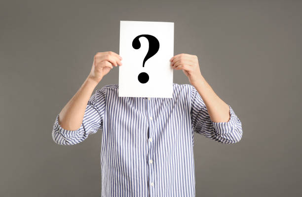 istock Man holding paper with question mark on grey background 1334132514