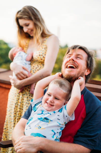 portret młodej szczęśliwej pary z dwójką małych dzieci - baby toddler young women outdoors zdjęcia i obrazy z banku zdjęć