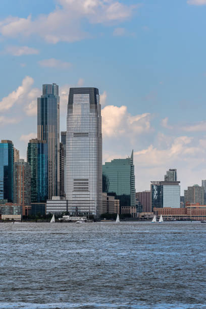 Vertical view of Jersey City's Hudson River waterfront, from Exchange Place to Newport, is known as Wall Street West, featuring the Goldman Sachs Tower. Jersey City, NJ - USA - July 30, 2021: Vertical view of Jersey City's Hudson River waterfront, from Exchange Place to Newport, is known as Wall Street West, featuring the Goldman Sachs Tower. logan west stock pictures, royalty-free photos & images