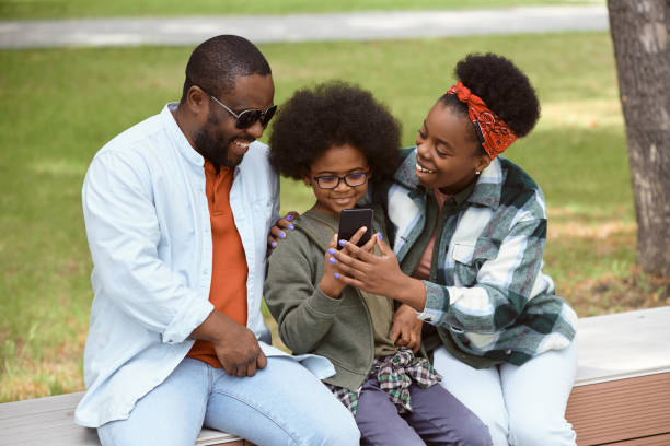 istock Happy parents and their son looking at smartphone screen 1334137229