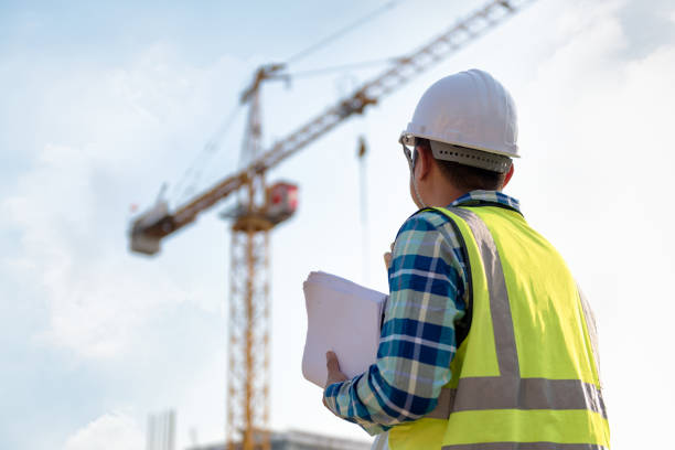 ingegneri consulting persone in cantiere che tengono il progetto in mano e controllano il flusso di lavoro del nuovo edificio. - manovale foto e immagini stock