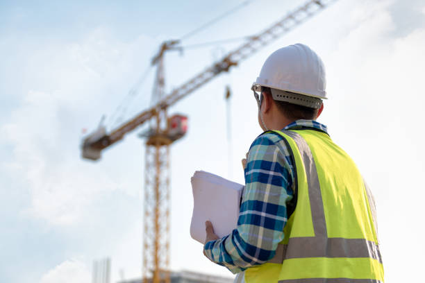 engineering consulting people on construction site holding blueprint in his hand and control workflow of the new building. - crane imagens e fotografias de stock
