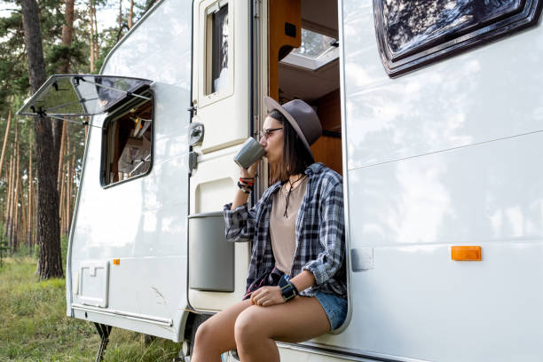 istock Young woman in hat and casualwear drinking tea while relaxing on hike 1334140146