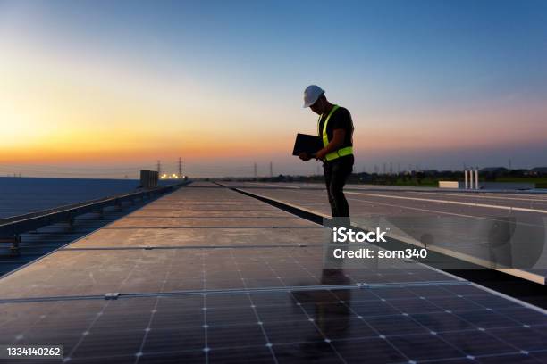 Technician Checking Photovoltaic Cells Panels On Factory Roof Maintenance Of The Solar Panels Engineer Service Inspecor Concept Silhouette Photo Stock Photo - Download Image Now