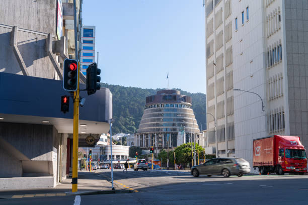 View up Whitmore Street in central city with county's government building know as Beehive Wellington New Zealand - July 28 2021;  waterfront at dawn with golden glow  on horizon just before sunrise. beehive new zealand stock pictures, royalty-free photos & images