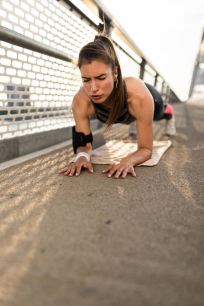 istock Young woman in plank position exercising at the bridge 1334151960