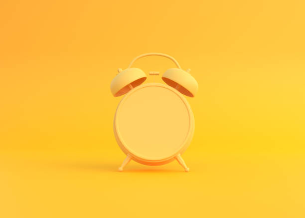 istock Yellow table alarm clock on bright yellow background in pastel colors 1334152913