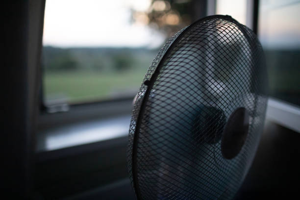 istock Cooling fan in the light hot summer night by the open window. 1334152942