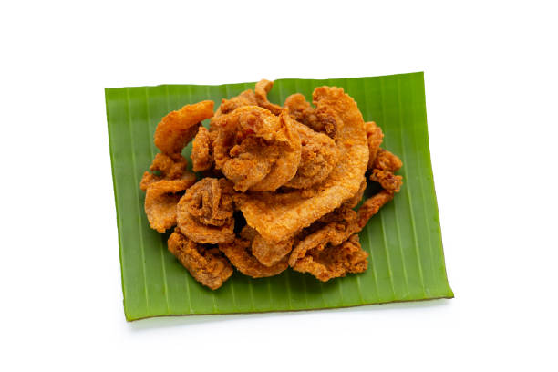 istock Fried crispy pork belly recipe on banana leaf on white background. 1334160040