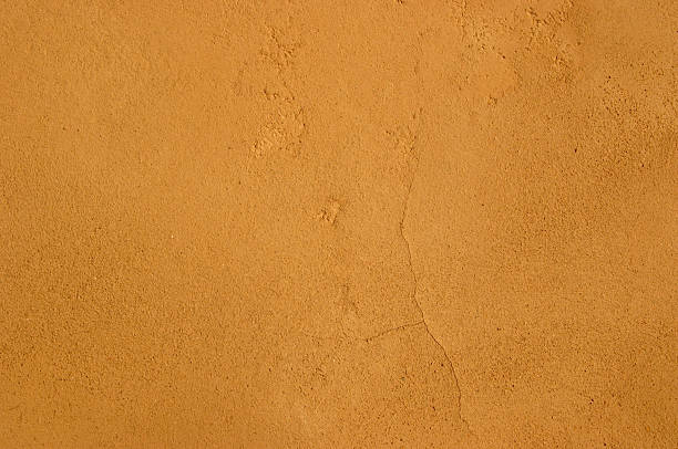 Mediterranean Earth Tone Typicall Mediterranean clay plaster surface, adobe sandy texture with tiny hair cracks. adobe material photos stock pictures, royalty-free photos & images