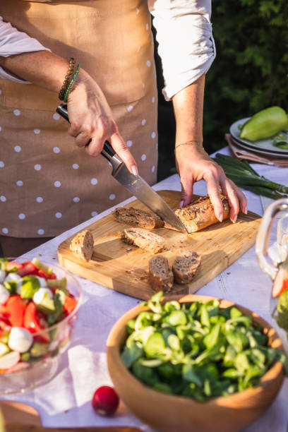 Woman cutting wholegrain baguette