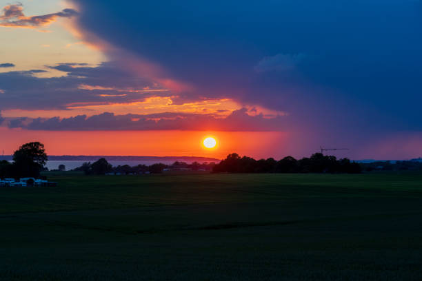 Red summer sunset over green fields in Glumslov, Sweden. Denmark at the horizon.