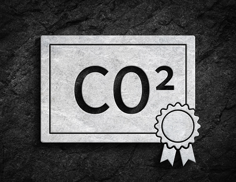 White co2 emissions trading symbol ETS license paper symbol on dark stone wall background