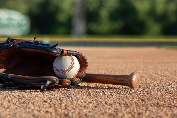 istock Baseball in a mitt with a brown bat low angle selective focus view on a baseball field 1334171722