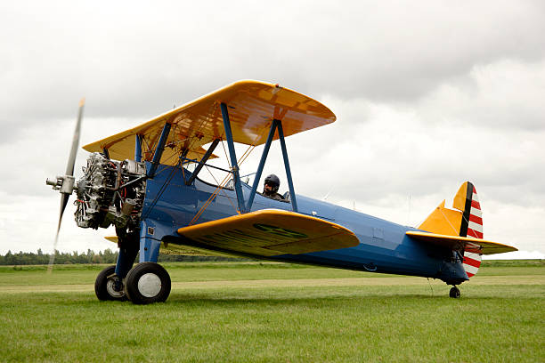 Biplane starting up its engines in a field Beautiful restored Boeing Stearman biplane with 15 Liter Starengine.  piloting photos stock pictures, royalty-free photos & images