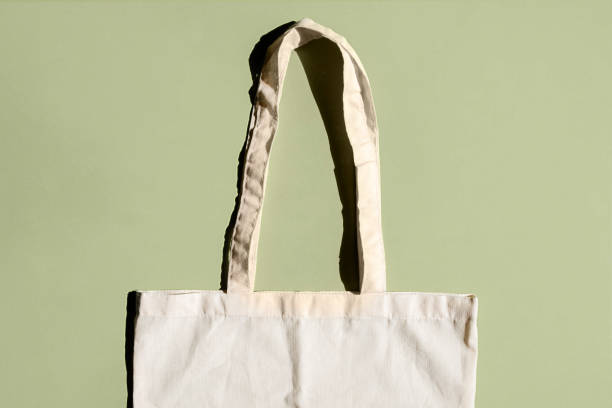 istock Reusable cotton shopping bag on green and beige background. Zero waste concept. No plastic 1334181422