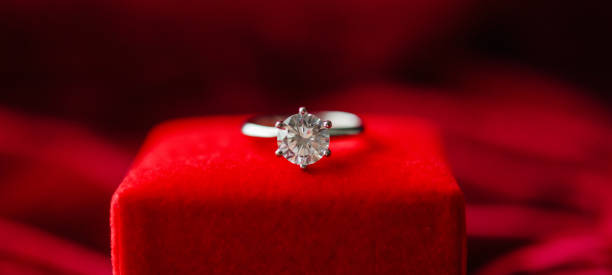 istock Diamond ring with jewelry gift box on red fabric background 1334182709