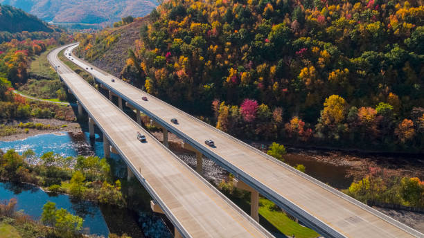 light traffic on the high bridge over the lehigh river at the pennsylvania turnpike between mountains in appalachian on a sunny day in fall. - rapid appalachian mountains autumn water imagens e fotografias de stock