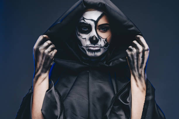 istock Female death in black hooded cape 1334184910