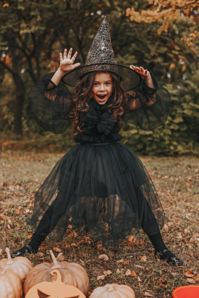 petite sorcière le jour d’halloween dans le parc - enfants seulement photos et images de collection