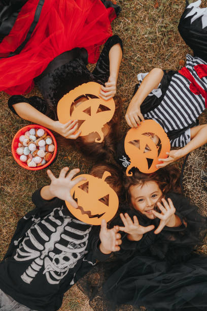 niños con caramelos y máscaras de calabaza espeluznantes - halloween pumpkin party carving fotografías e imágenes de stock