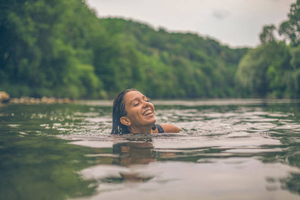 istock Young woman swims down lakeshore, in summer 1334197700