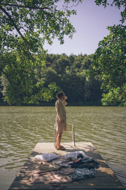 istock Young man enjoys a coffee on dock near lakeshore 1334202366