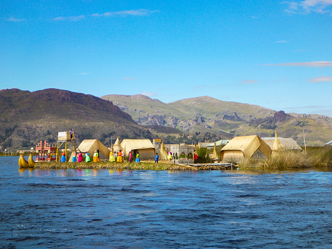 Personas que viven en la isla flotante de los Uros en el lago Titicaca cerca de Puno, Perú photo