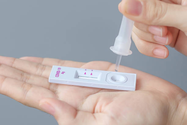 istock man swab COVID-19 testing by Rapid Antigen Test kit. Coronavirus Self nasal or Home test, Lockdown and Home Isolation concept 1334213394