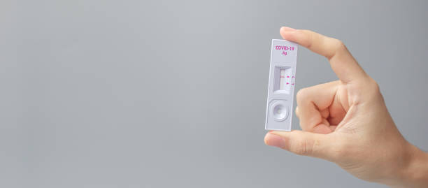 istock man holding Rapid Antigen Test kit with Negative result during swab COVID-19 testing. Coronavirus Self nasal or Home test, Lockdown and Home Isolation concept 1334213981