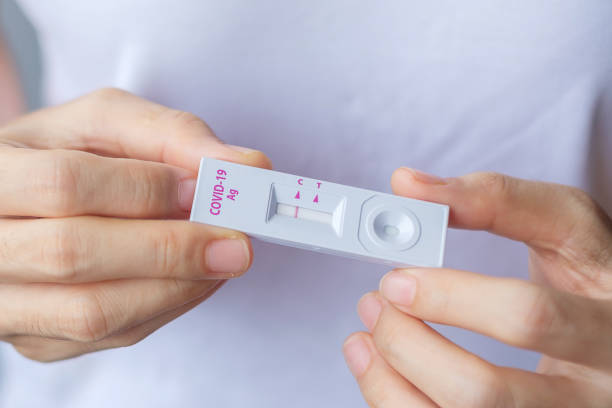 istock man holding Rapid Antigen Test kit with Negative result during swab COVID-19 testing. Coronavirus Self nasal or Home test, Lockdown and Home Isolation concept 1334213983