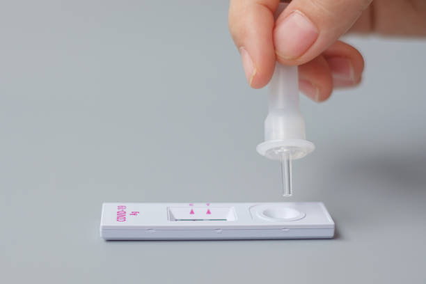 istock man swab COVID-19 testing by Rapid Antigen Test kit. Coronavirus Self nasal or Home test, Lockdown and Home Isolation concept 1334214018