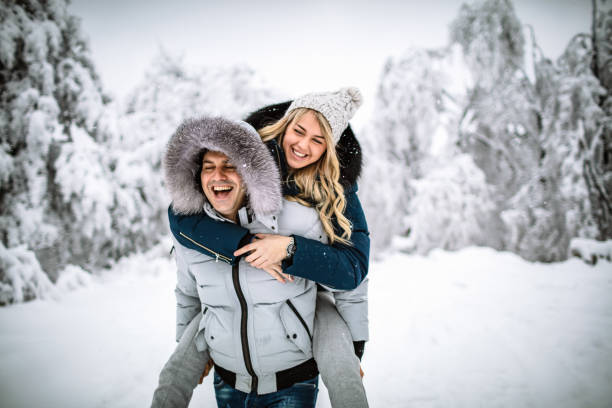 Happy couple on a snowy day Photo of happy couple on a snowy day snowdrops in woodland stock pictures, royalty-free photos & images