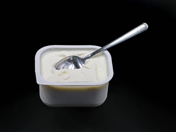 istock low-fat quark in plastic container with spoon isolated on black background 1334229075
