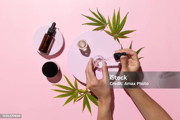 Bottles With Cbd Oil Thc Tincture And Cannabis Leaves On Pink Background Alternative Cosmetics Medical Concept Stock Photo - Download Image Now