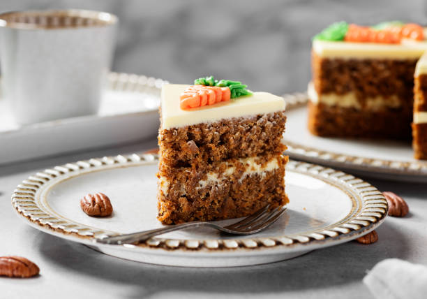 Carrot layered cake Carrot layered cake with cream cheese frosting decorated with carrots. carrot cake stock pictures, royalty-free photos & images