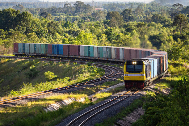 um trem de carga enquanto passa pelos campos verdes. - goods vehicle - fotografias e filmes do acervo