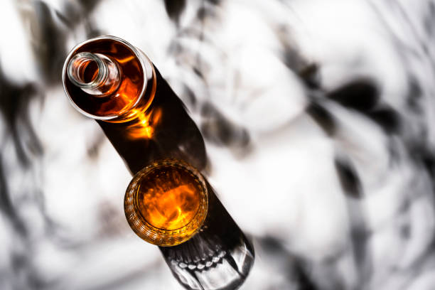istock American bourbon whiskey in glasses and bottle, white  background with shadow pattern and negative space. Hard light 1334233645