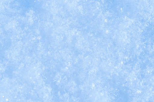 White background with snowflakes close-up of soft snow surface and soft shadows.