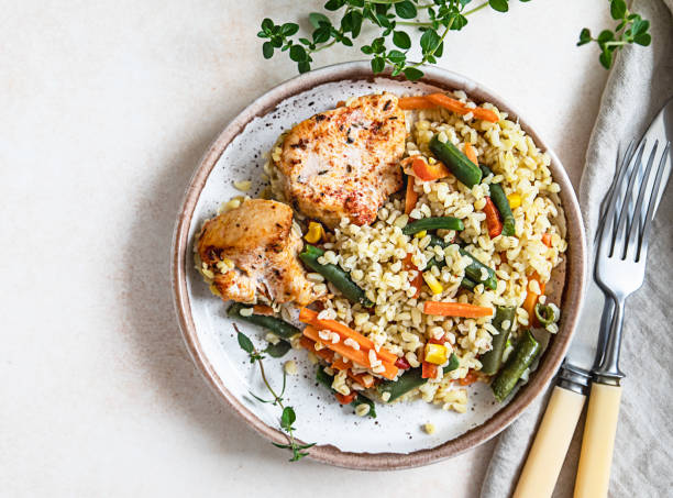istock Baked chicken or turkey breast with bulgur and vegetables on a plate. Top view. 1334236071