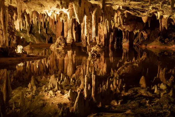 Photo of Subterranean lake in magnificent cave reflects intricate rock formations