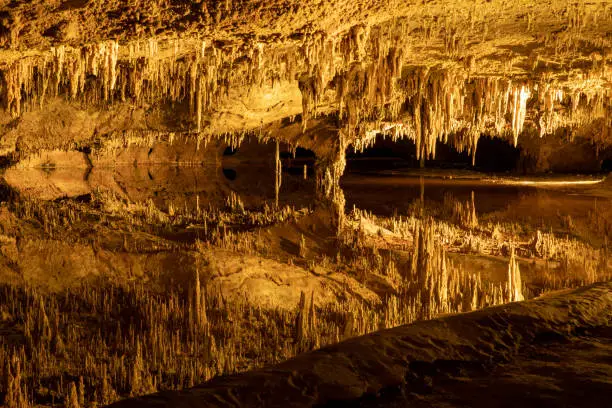Photo of Beautiful underground lake in a deep cave reflects majestic surreal rock formations