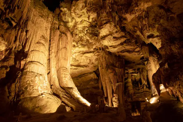 Photo of Giant pillars of rock and majestic geological formations in underground cave.